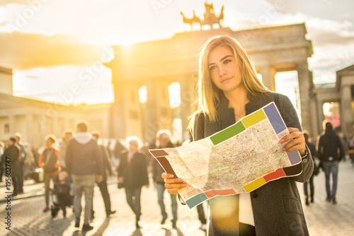 Portrait of young woman with map near Brandenburg Gate in Berlin, Germany.