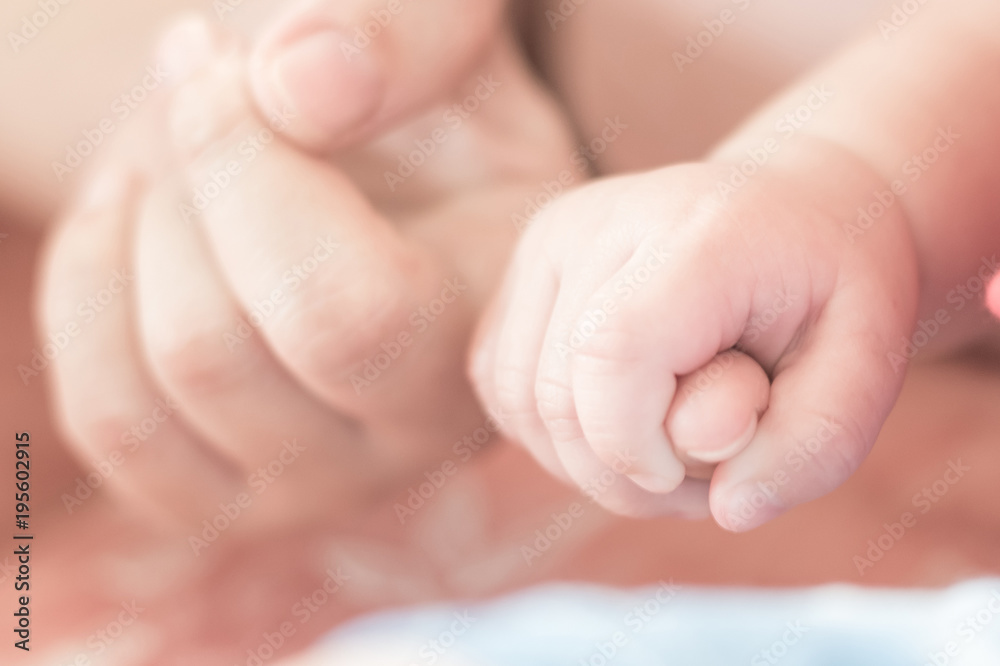 Newborn baby hands holding mother's finger blur background for child adoption, kid parenting and family nursing new born infant concept