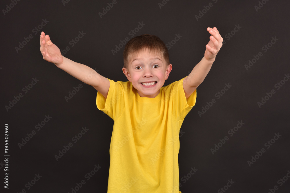 Emotional guy. Portrait of a boy in a T-shirt. Shooting in the studio. A young man on a black background. Emotional guy. Portrait of a boy in a T-shirt. Shooting in the studio. A young man on a black background.