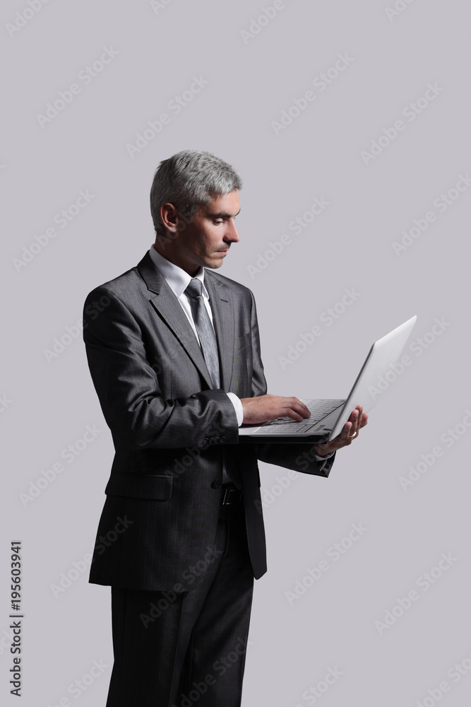 businessman standing with an open laptop