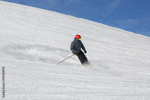 High speed skiing down the slope. Extreme ski slope in winter sunny day at alpine ski resort. photo