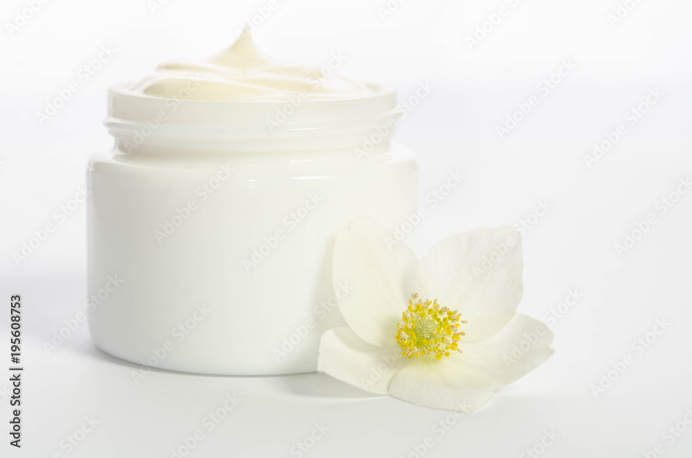 Cute flower and a jar of natural body cream isolated on white background