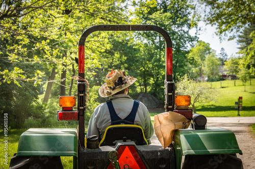 Hayride in farm on tractor, driver with birds on hat