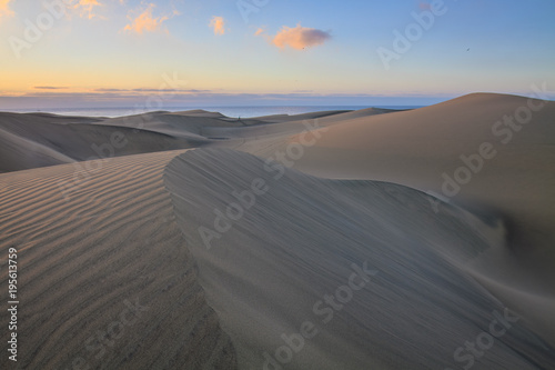 Small lonely runner on big dunes in Maspalomas, Gran Canaria island.
