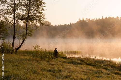 Morning fishing.  Fisherman fishing at lake. Foggy morning.