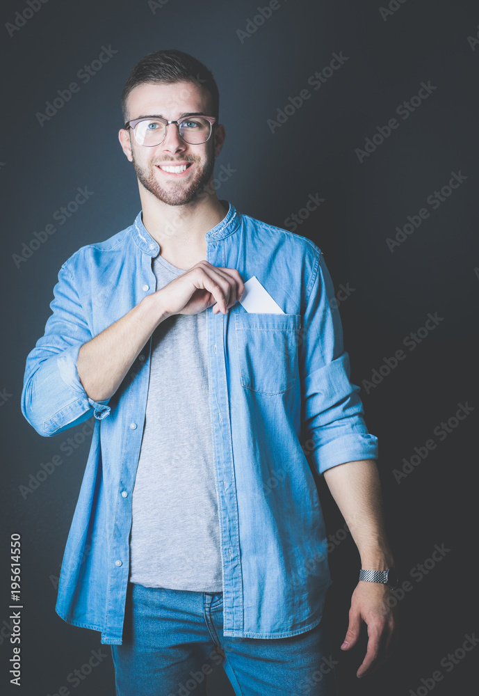 Young man holding a credit card standing on gray background. Young entrepreneur. Young man holding a credit card standing on gray background. Young entrepreneur.