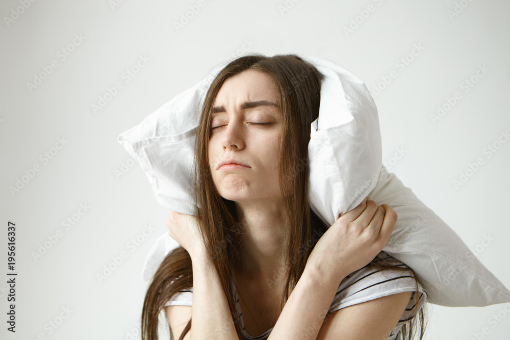 Stop making this annoying sound. Indoor shot of frustrated upset young woman with messy hair suffering from insomnia or some sleeping disorder, can't relax because of irritating dripping water sound Stop making this annoying sound. Indoor shot of frustrated upset young woman with messy hair suffering from insomnia or some sleeping disorder, can't relax because of irritating dripping water sound