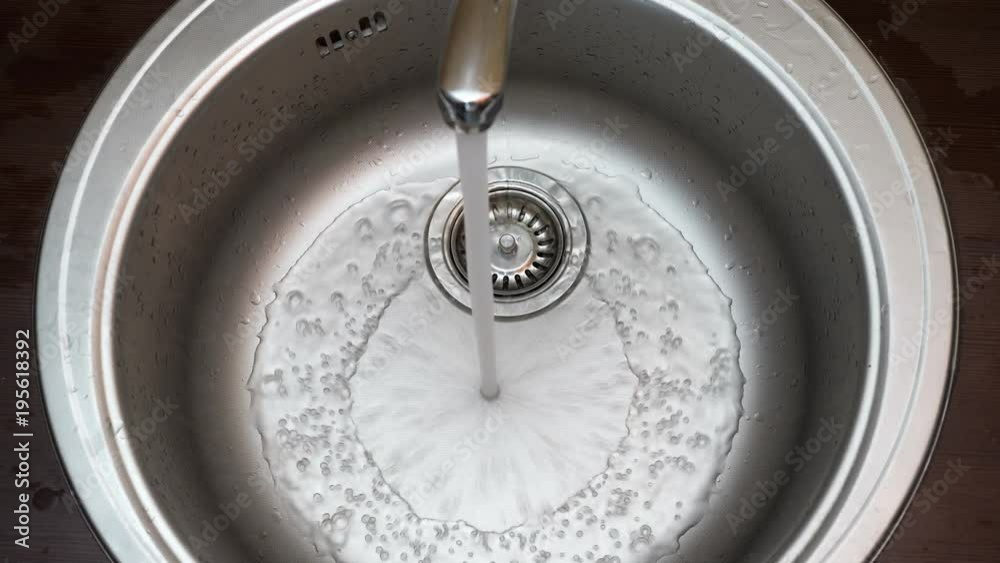 Streaming water in sink. Water stream going down the drain.
Streaming water in sink. Water stream going down the drain.