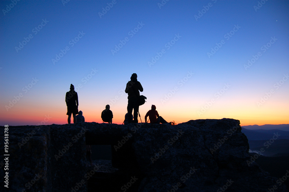 Fototapeta premium Tourists watch the sun rise on the mountain