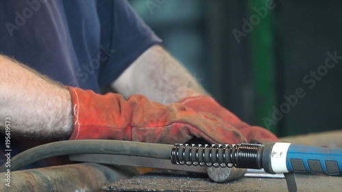 Hand Ironworker forging hot iron in workshop whith hammer. Hands of blacksmith making horseshoe