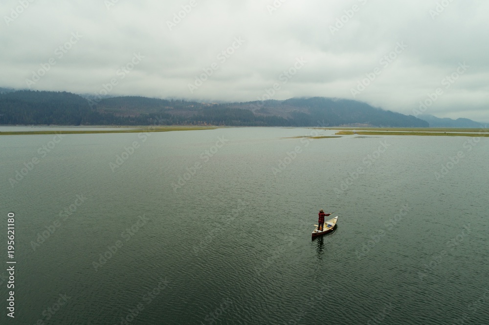 Man travelling in canoe against cloudy sky Man travelling in canoe against cloudy sky