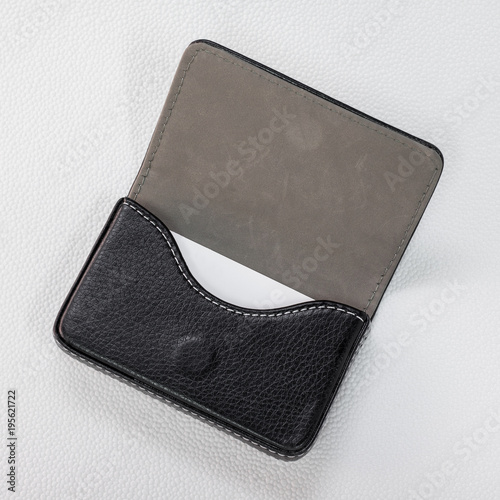 Black leather card holders and white card on synthetic white background. Top view of Leather wallet for keep your money.
