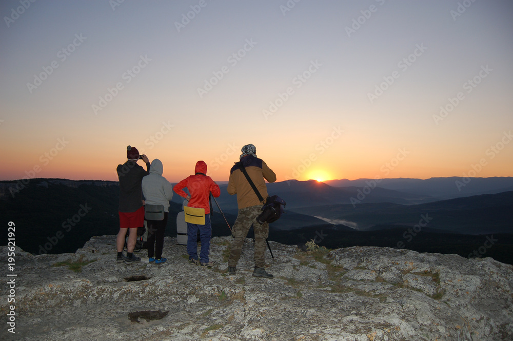 tourists watch the sun rise on the mountain