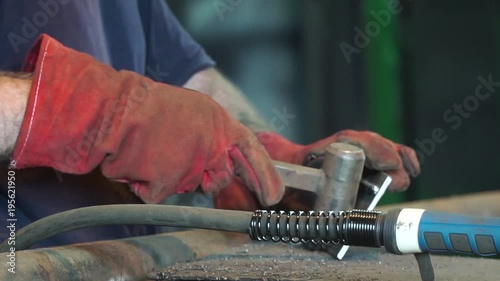 Hand Ironworker forging hot iron in workshop whith hammer. Hands of blacksmith making horseshoe