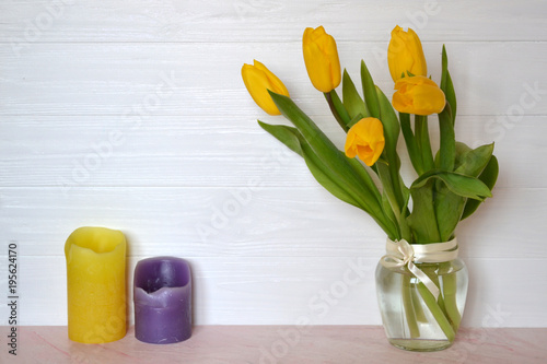 Yellow tulips in vase on the table. Spring background.