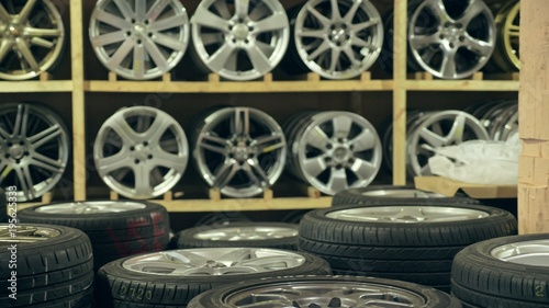 Alloy wheels in the store on the shelves. The camera moves from left to right. The discs are different and new. photo