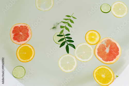 Milk water in the bath, which swim citrus: lime, lemon and grapefruit. Skin care and relaxation photo