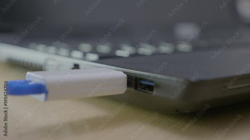 Male student plugging in an memory data stick into teachers usb laptop port to download his project and them safely removing it Male student plugging in an memory data stick into teachers usb laptop port to download his project and them safely removing it