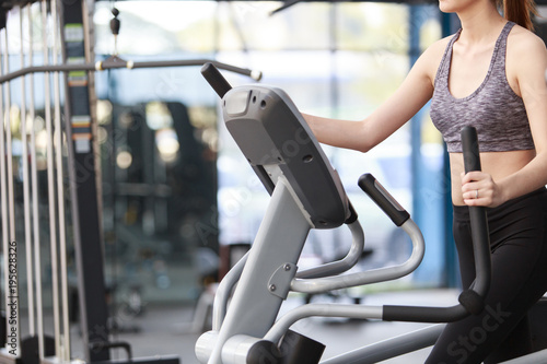 Close-up footage of a women working out in gym on the exercise bike, young woman cycling in the gym. female exercising in fitness gym for good health.