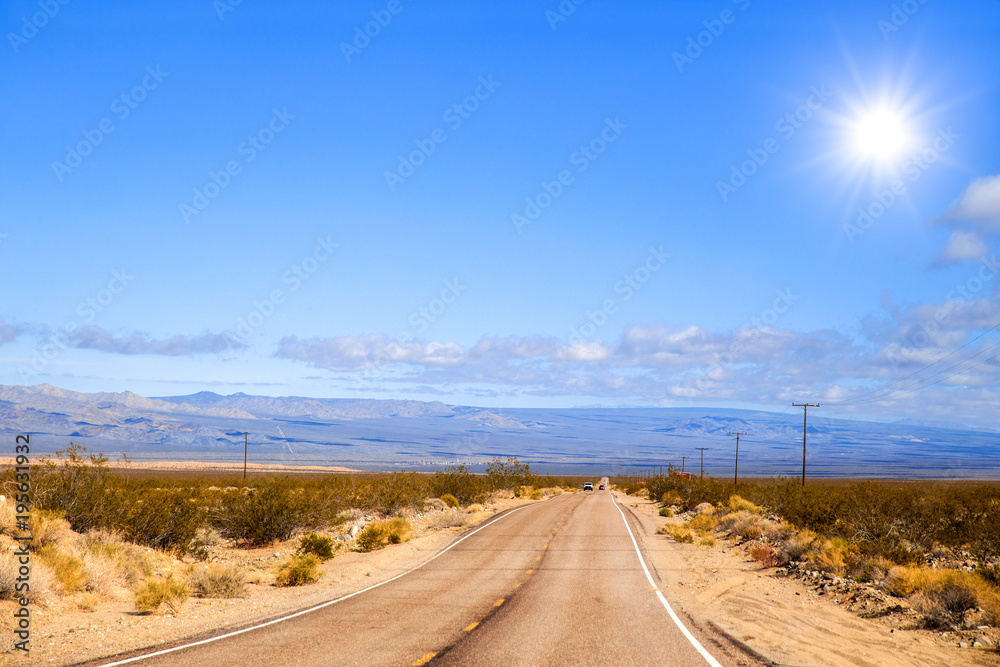 A long narrow stretching across a flat desert floor with mountains in the background in a spring time landscape A long narrow stretching across a flat desert floor with mountains in the background in a spring time landscape