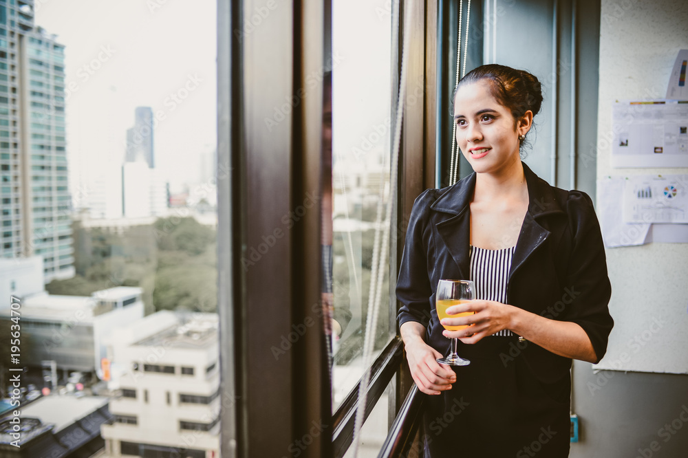 smile of beautiful business woman at the window with champagne