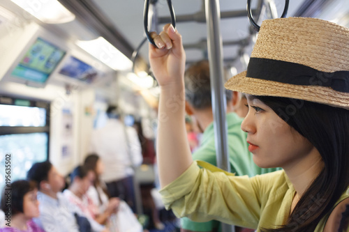Asian woman standing in the train and the background blurred. © Somkiat