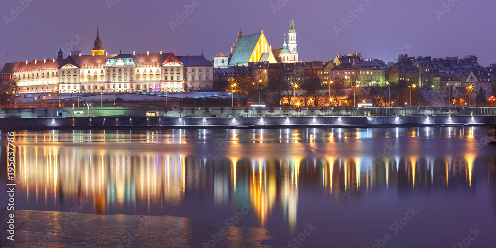 Panorama of the Old Town with reflection in the Vistula River during evening blue hour, Warsaw, Poland.