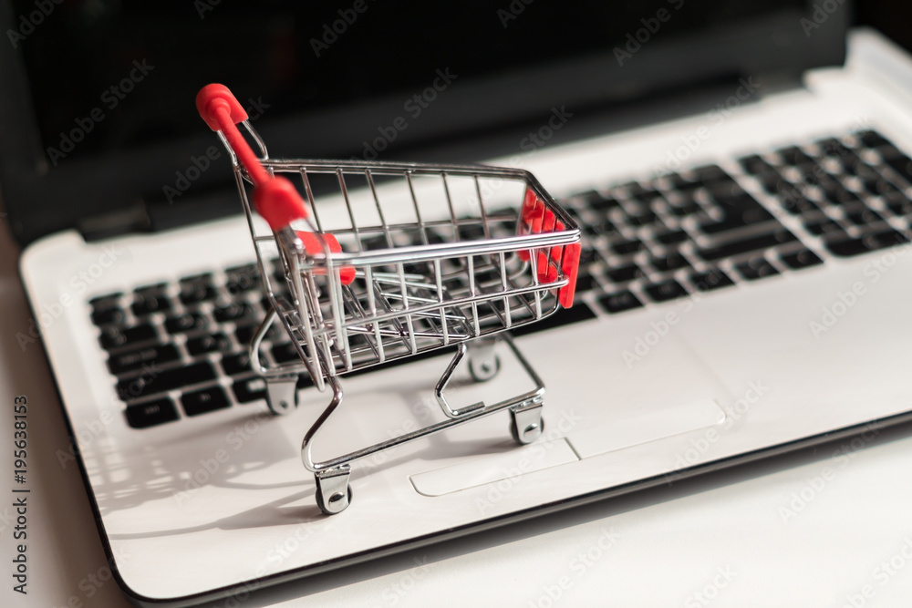 Small red shopping cart on laptop, Technology business online shopping concept Small red shopping cart on laptop, Technology business online shopping concept