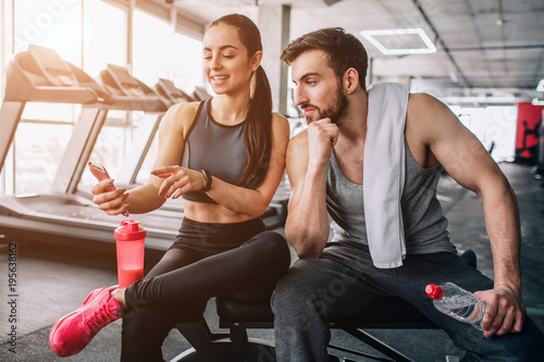 Fotografie Attractive and nice people sitting on the sport bench and relaxing after long-term exercising