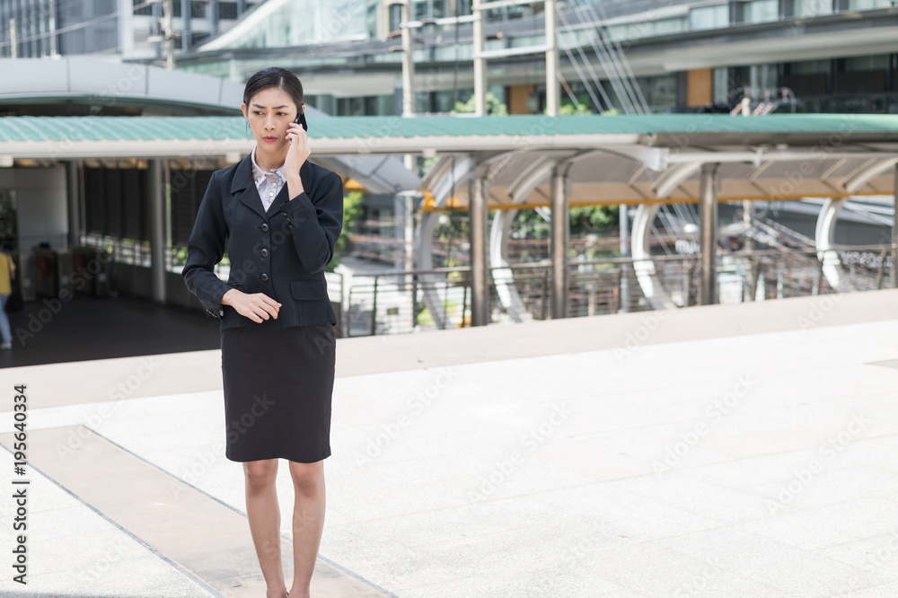 Asian business woman hold cell phone to talk about business plan, and copy space for text Asian business woman hold cell phone to talk about business plan, and copy space for text