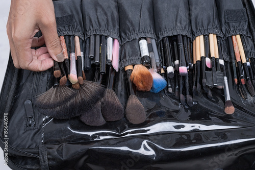 Young beautiful woman applying make-up by make-up artist