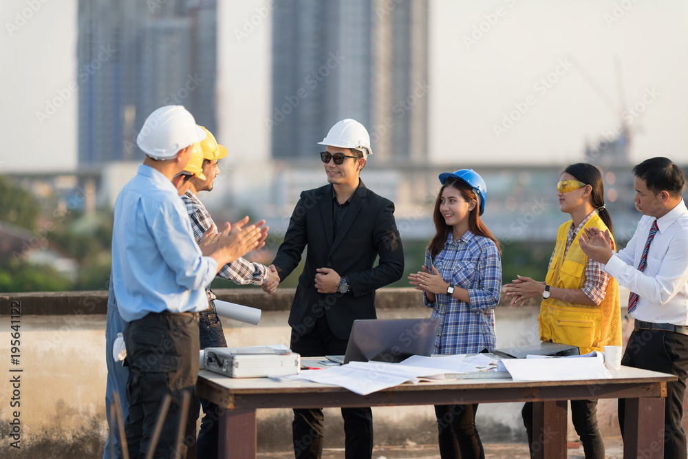 Business man handshake with engineer with teamwork over rooftop. Success in engineering project. Architectural project achievement. Business man handshake with engineer with teamwork over rooftop. Success in engineering project. Architectural project achievement.