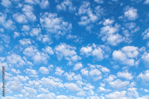 Nice small clouds. Cute fluffy cirrus clouds on a blue sky, background with a gradient effect.