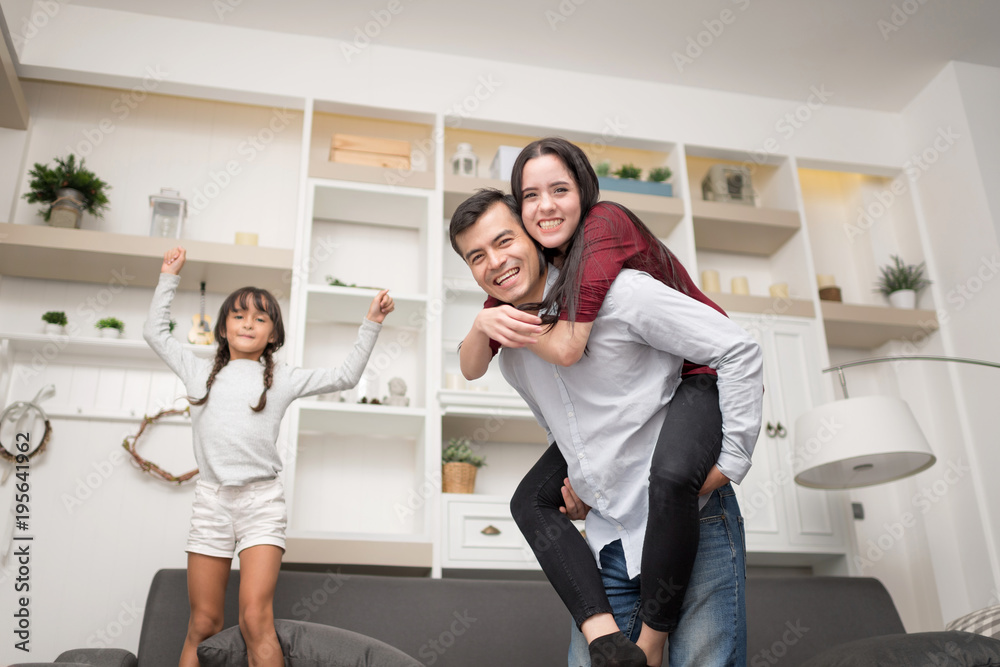 Happy Family spending time together at home.In selective focus of funny ride on back and run around. Happy Family spending time together at home.In selective focus of funny ride on back and run around.