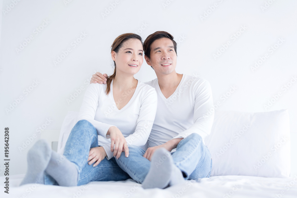 Happy relax couple smiling and embrace while sitting on the bad. Happy relax couple smiling and embrace while sitting on the bad.