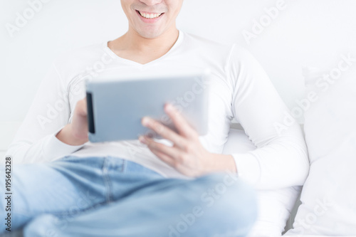 Young man working with digital tablet at home. selective focus at his mouth.