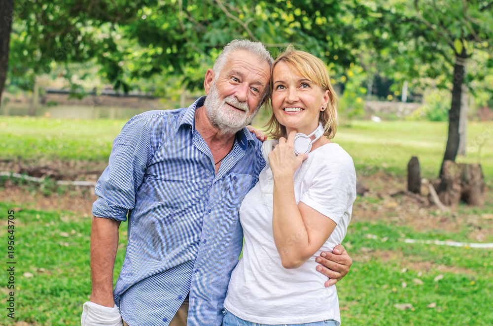 Fototapeta premium Happy old couple smiling in a park on a sunny day