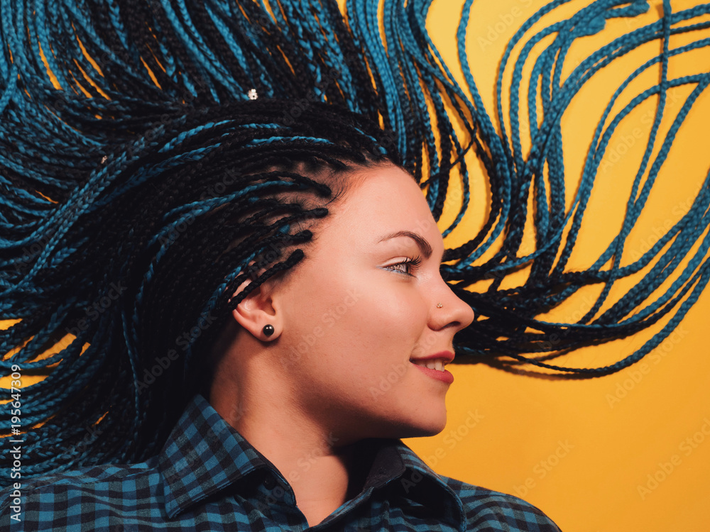 Beautiful young girl with african blue braids. Woman on bright yellow background. Dyed Hair moves. Hipster. - obrazy, fototapety, plakaty 