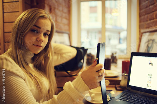 young woman working on laptop in cafe  concept of remote work  training  student preparing for exams  girl with gadget in restaurant