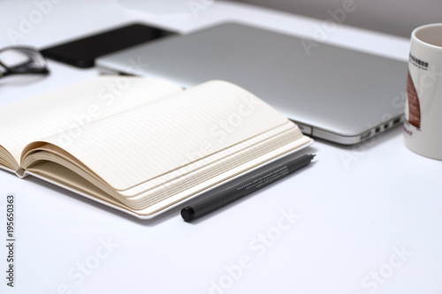 Notebook, pen and Laptop on White background