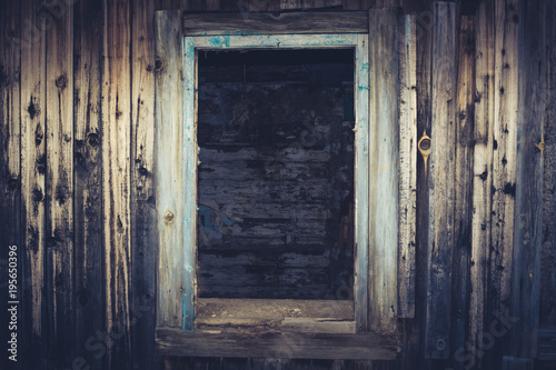Empty window opening of the old abandoned house. Blue toned image.