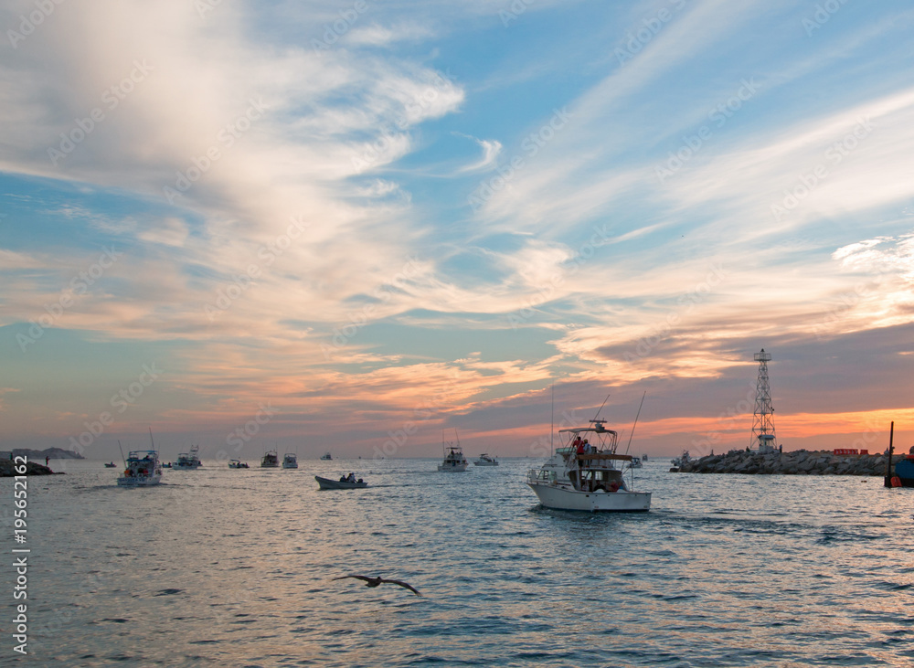 Fishermans sunrise view of fishing boat going out for the day past Lands End in Cabo San Lucas in Baja Mexico