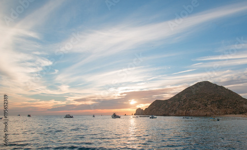 Fishermans sunrise view of fishing boat going out for the day past Lands End in Cabo San Lucas in Baja Mexico