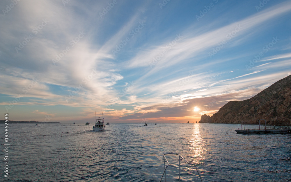 Fishermans sunrise view of fishing boat going out for the day past Lands End in Cabo San Lucas in Baja California Mexico