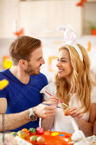 Woman and man coloring Easter eggs