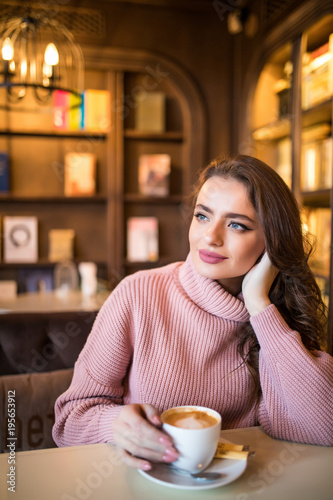 Young pretty woman drink coffee in cafe shop photo