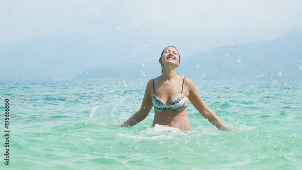 Pretty woman splashing in the sea. Relaxing on vacation Pretty woman splashing in the sea. Relaxing on vacation