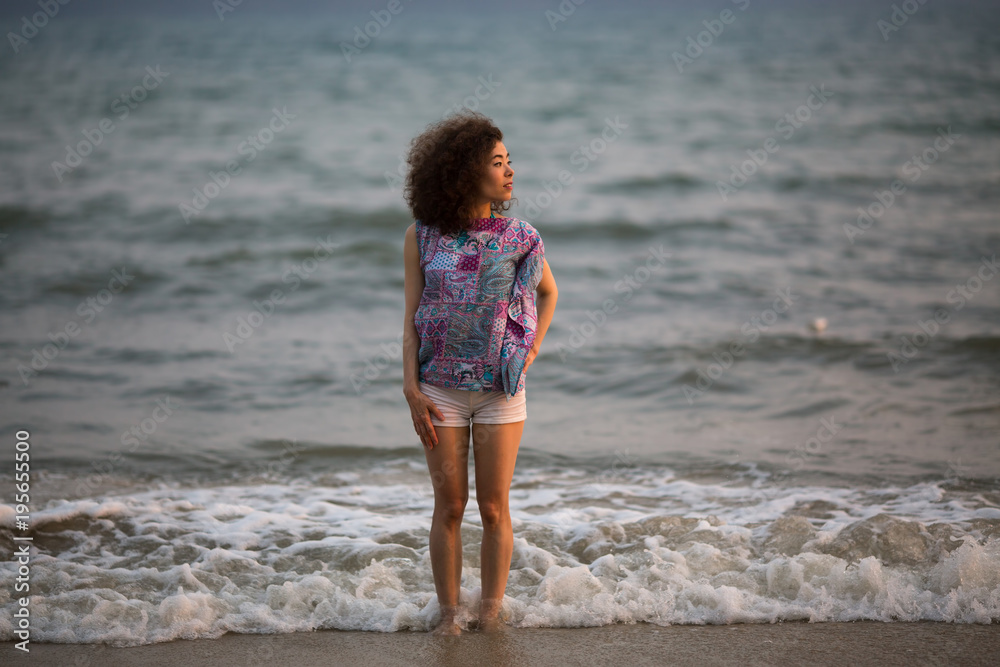 Young mixed race woman walking on the sea beach. Young mixed race woman walking on the sea beach.