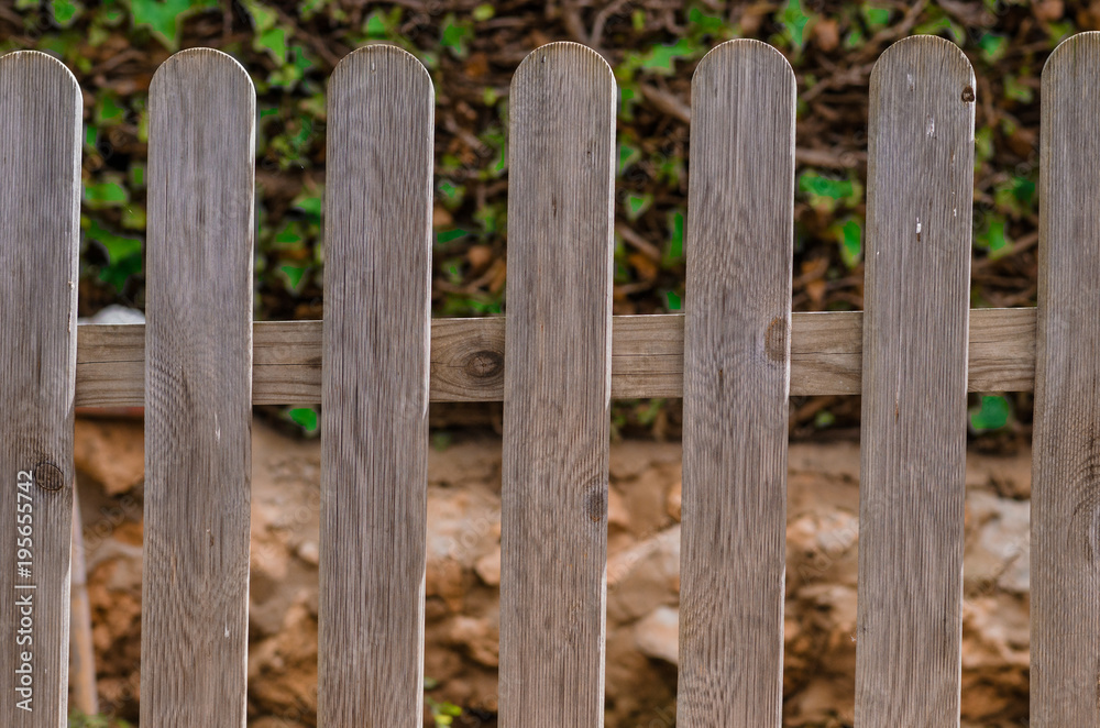 Fotografía de una verja de madera en el jardín de casa.