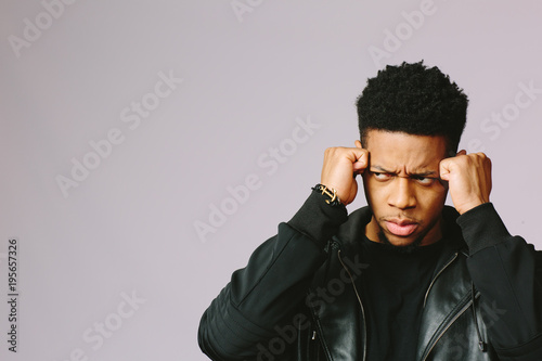 Billede på lærred An angry and troubled young man looking to the side, isolated on grey background